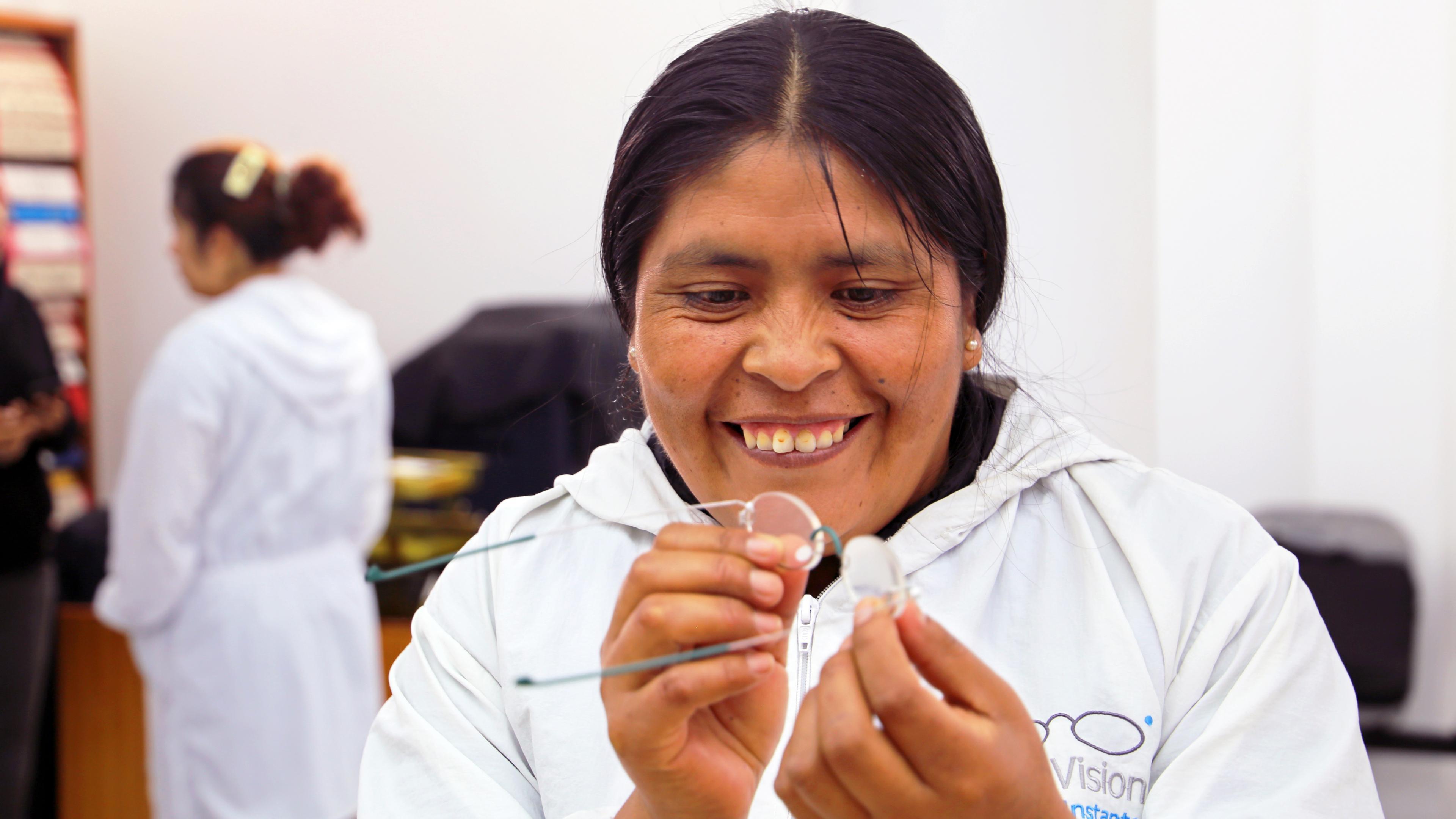 Peruanische Frau mit weißer Kleidung fertigt eine Brille