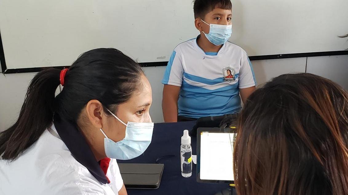 Mitarbeiterin von GoodVision Bolivien im Gespräch mit der Mutter eines jungen Patienten